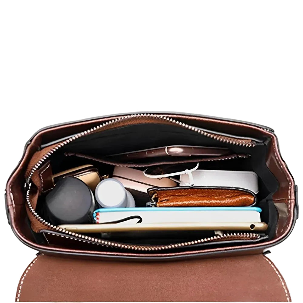 Sac à main en cuir véritable marron avec compartiments et fermeture zippée rempli d’articles personnels