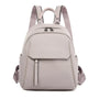 Sac à dos en cuir synthétique gris clair avec zippers noirs et bretelles ajustables