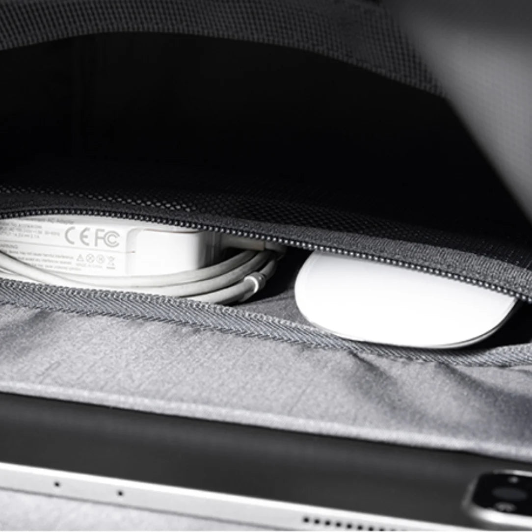 Intérieur du sac Roll top Nebula XB avec chargeur, câble enroulé et souris blanche