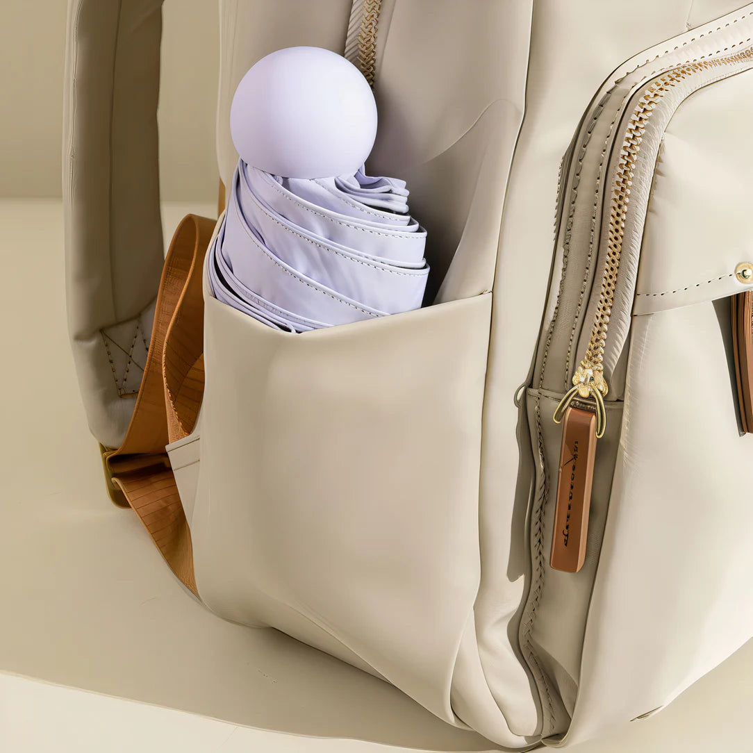 Sac à dos Amber en crème avec zippers dorés et accents en cuir marron