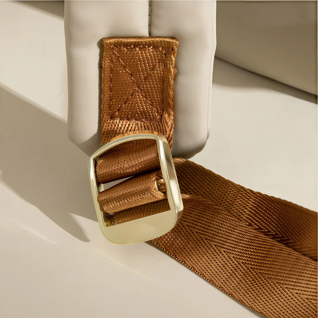 Ce sac à dos Amber avec ceinture à boucle en or, sangle en marron et doublure en tissu