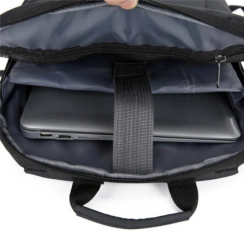 Sac à dos collège ordinateur noir ouvert avec un ordinateur portable gris à l’intérieur