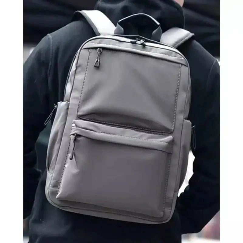 Sac à dos cours en toile gris foncé avec plusieurs compartiments zippés