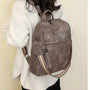 Sac à dos cuir souple gris en faux cuir, bandoulière rayée et charm tassel