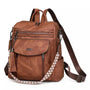 Sac à dos en cuir végétal marron avec plusieurs zippers et une bandoulière à motif