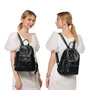 Sac à dos femme de ville en cuir noir avec poche zippée avant et pompons latéraux