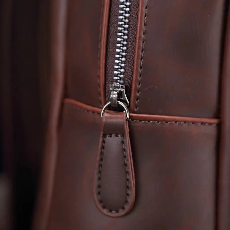 Premier plan d’un sac à dos homme cuir vintage avec fermeture éclair en métal