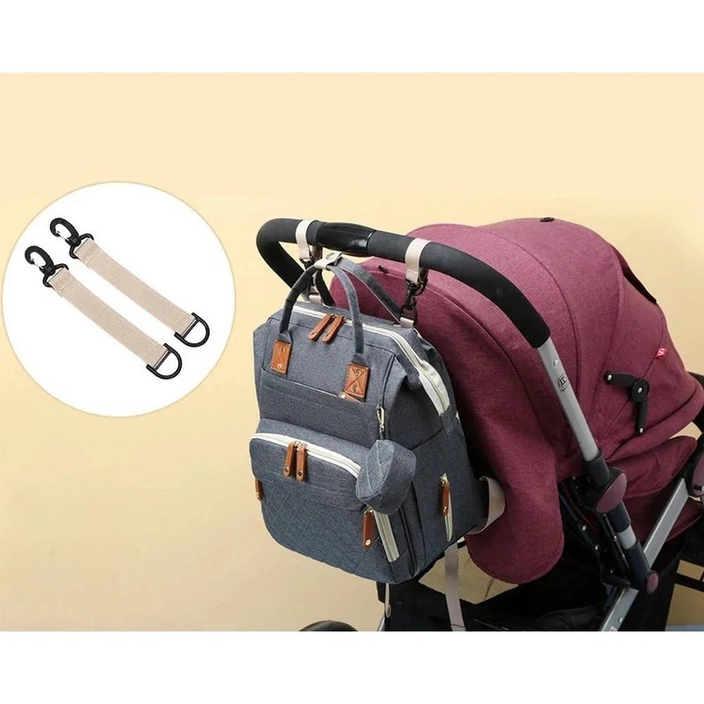 Sac à dos à langer 20L multipoches en denim bleu avec accents marron suspendu à une poussette