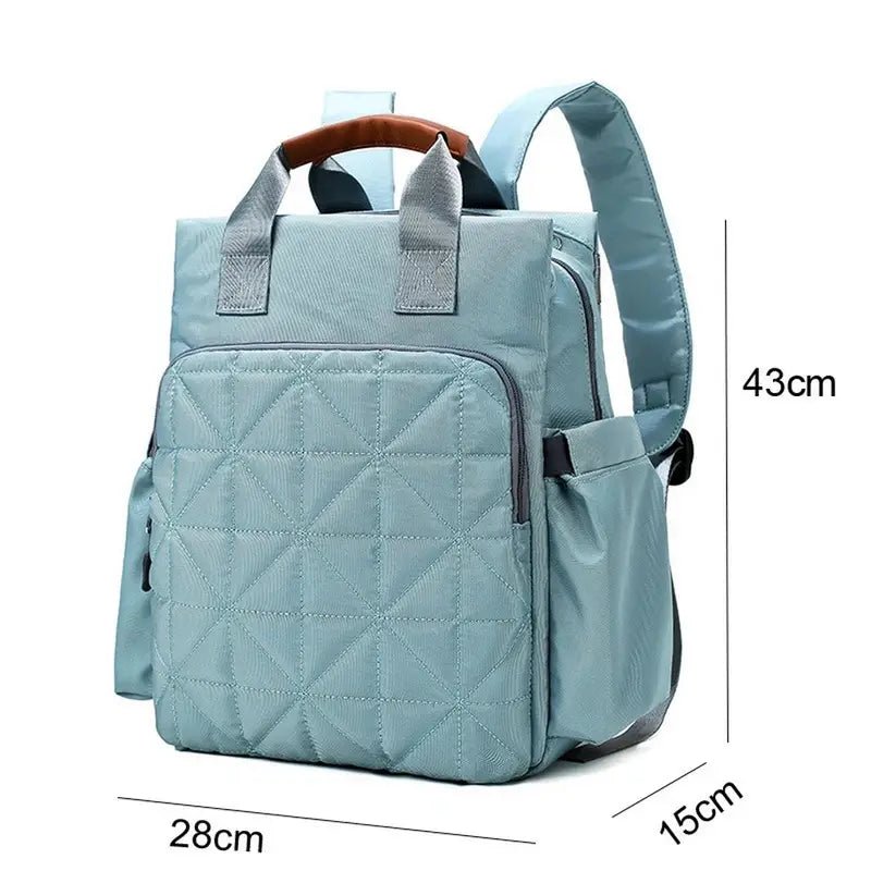 Sac à dos à langer bébé bleu clair matelassé avec poignée en cuir brun et poches latérales