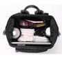 Sac à dos à langer design noir ouvert avec essentiels pour bébé et ordinateur portable