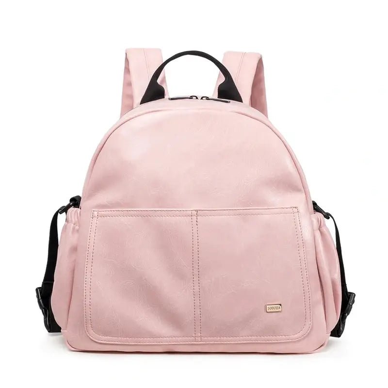 Sac à dos à langer en cuir rose avec bretelles noires et poches multiples