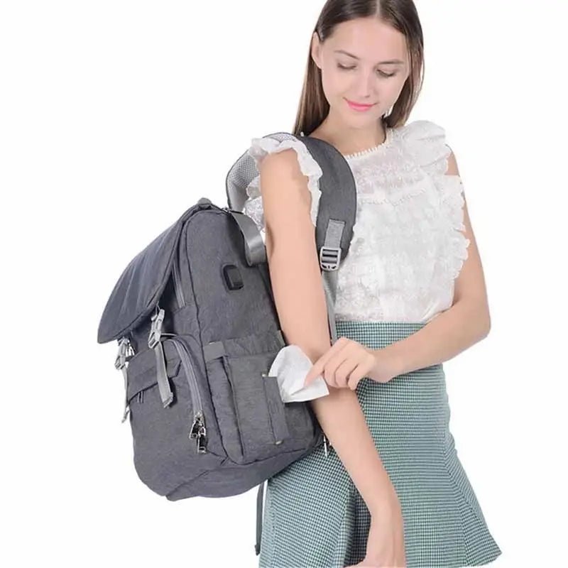 Sac à dos à langer ergonomique en gris foncé avec plusieurs poches et rabat