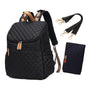 Sac à dos à langer noir en quilting avec accents tan, bandoulières détachables et tapis à langer assorti
