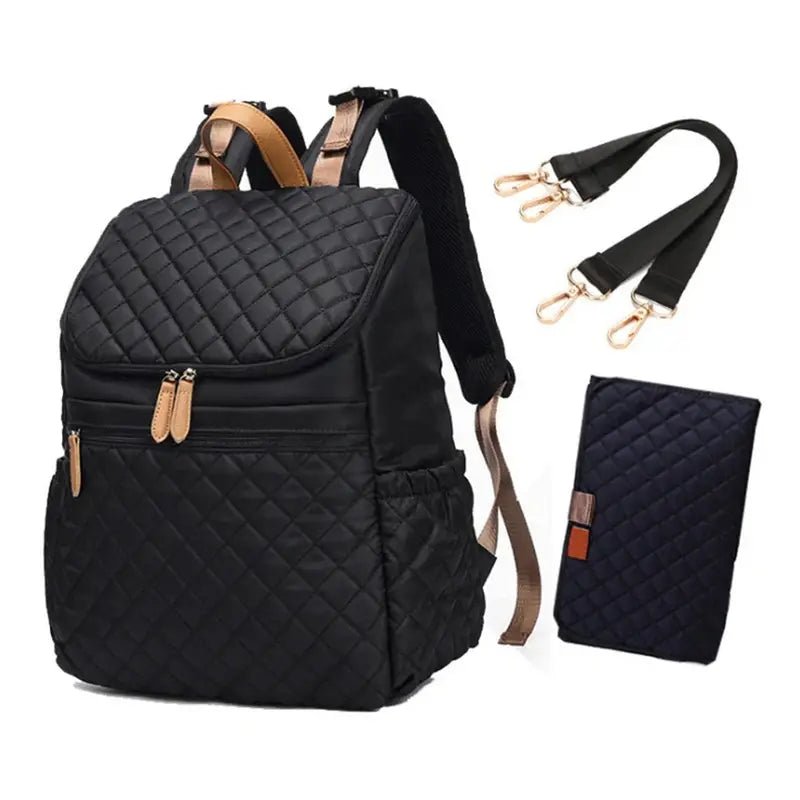 Sac à dos à langer noir en quilting avec accents tan, bandoulières détachables et tapis à langer assorti
