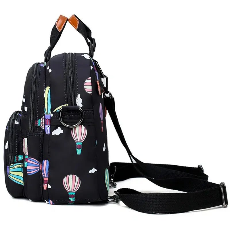 Sac à dos à langer en nylon noir avec motif de montgolfières colorées et nuages
