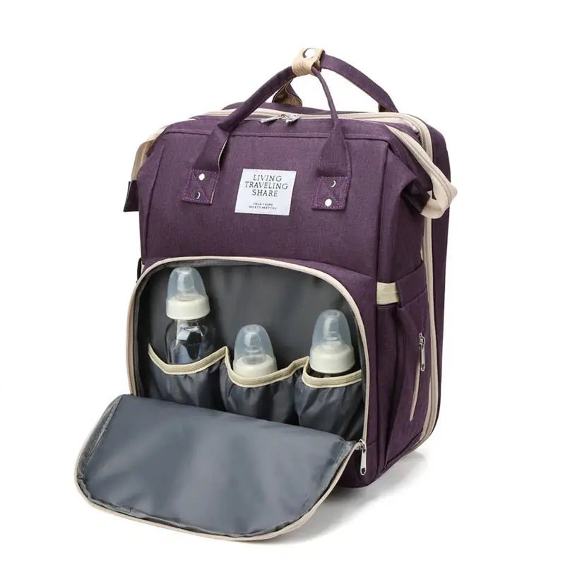 Sac à dos à langer usb violet avec poche frontale ouverte et trois biberons pour bébé