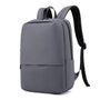 Sac à dos rectangulaire homme minimaliste gris avec bretelles rembourrées et nombreuses poches zippées
