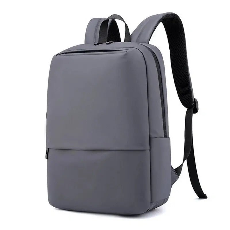 Sac à dos rectangulaire homme minimaliste gris avec bretelles rembourrées et nombreuses poches zippées