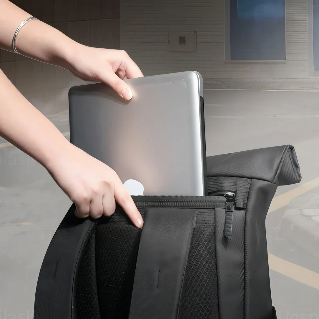 Personne plaçant un ordinateur portable argenté dans un sac à dos noir Knight avec compartiment PC