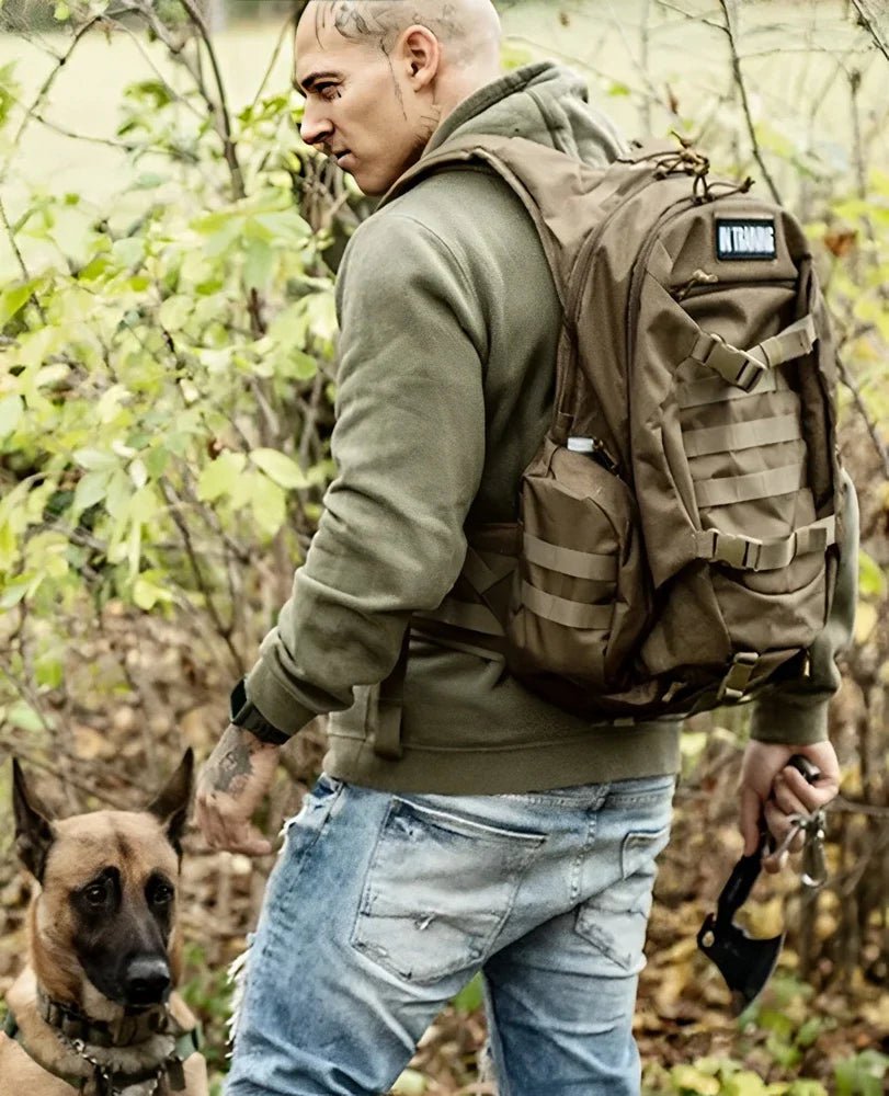 Homme en sweat à capuche et jeans avec sac à dos tactique militaire 35L 600D et chien