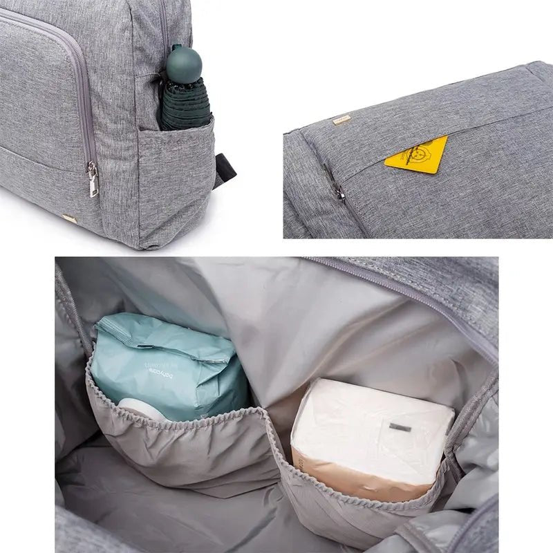Sac à langer à dos en tissu gris avec compartiments, contenant un parapluie et autres objets
